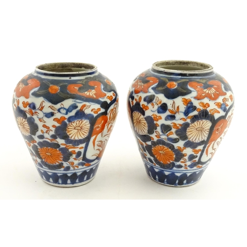 66 - A pair of Japanese vases decorated in the Imari palette decorated with flowers and foliage. Together... 