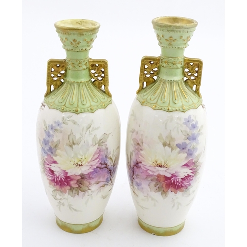 79 - A pair of Royal Bonn vases this twin gilt handles, decorated with hand painted flowers and foliage. ... 