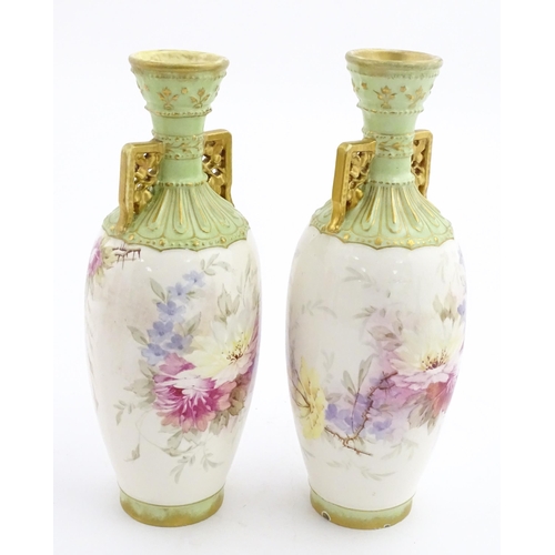 79 - A pair of Royal Bonn vases this twin gilt handles, decorated with hand painted flowers and foliage. ... 