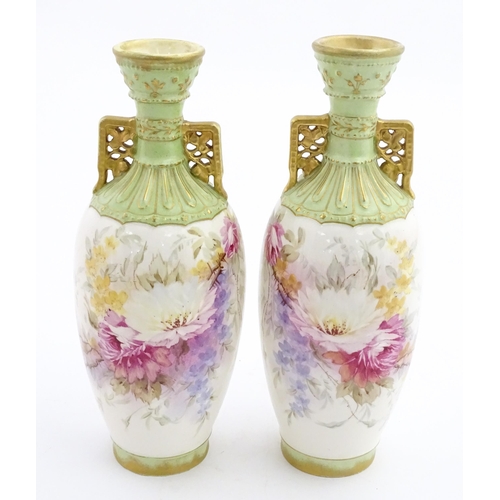 79 - A pair of Royal Bonn vases this twin gilt handles, decorated with hand painted flowers and foliage. ... 
