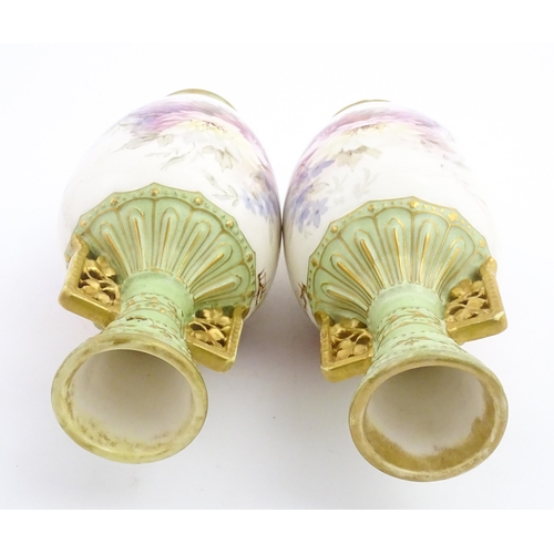79 - A pair of Royal Bonn vases this twin gilt handles, decorated with hand painted flowers and foliage. ... 