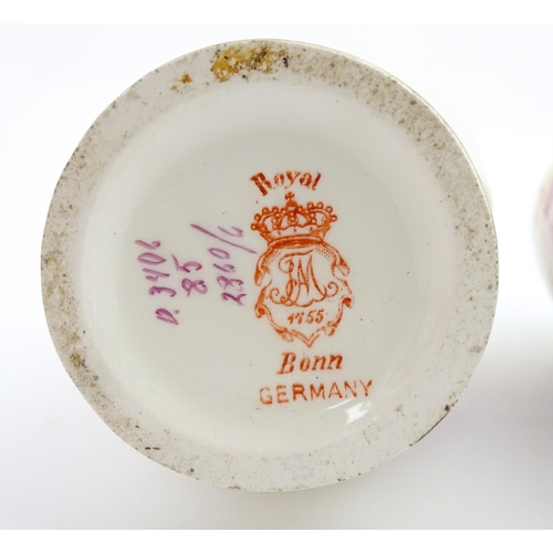 79 - A pair of Royal Bonn vases this twin gilt handles, decorated with hand painted flowers and foliage. ... 