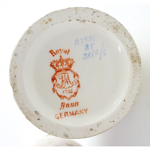 79 - A pair of Royal Bonn vases this twin gilt handles, decorated with hand painted flowers and foliage. ... 