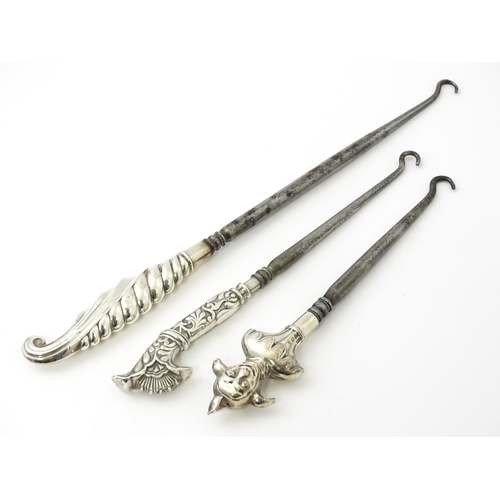 361 - Three various silver and white metal handled button hooks including one with floral and scroll detai... 