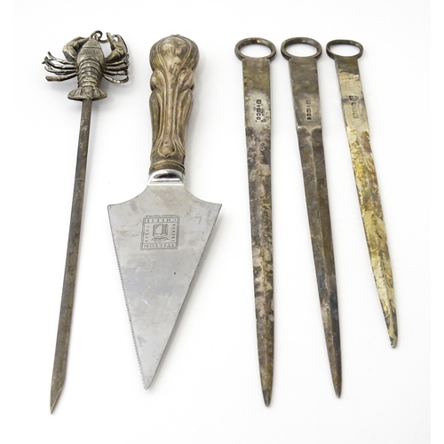 412 - Assorted items to include three silver plate meat skewers, a skewer surmounted by a model of a lobst... 