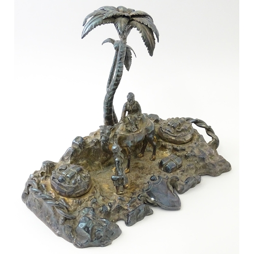 371 - A Victorian silver plate inkstand modelled as a man riding a camel with an attendant below two palm ... 