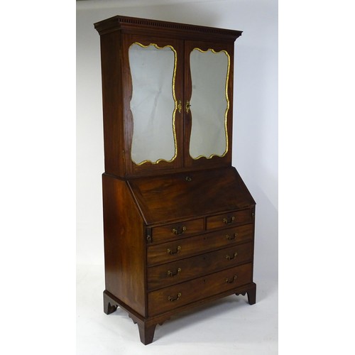 1431 - A George II mahogany bureau bookcase with a moulded cornice above two mirrored doors opening to show... 