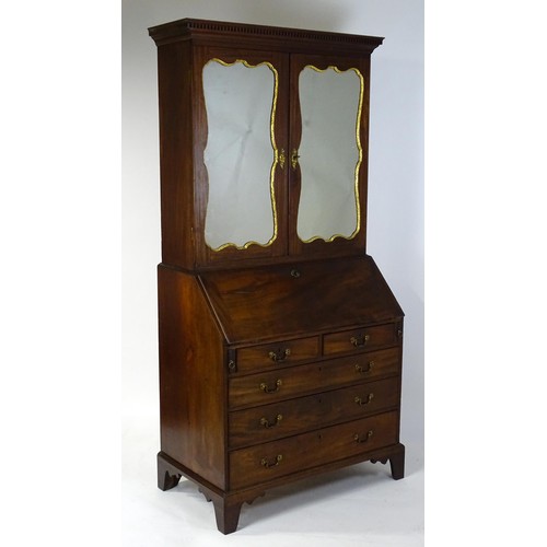 1431 - A George II mahogany bureau bookcase with a moulded cornice above two mirrored doors opening to show... 