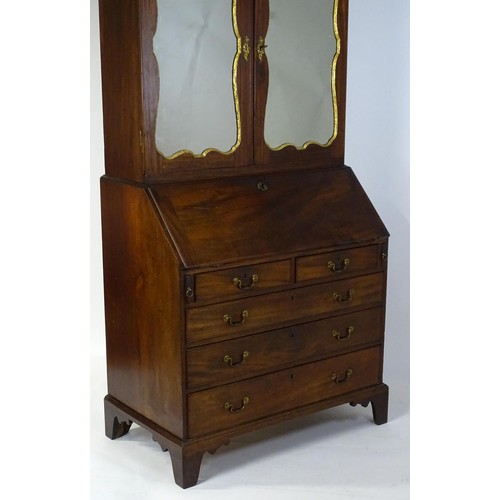 1431 - A George II mahogany bureau bookcase with a moulded cornice above two mirrored doors opening to show... 