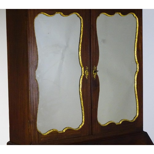 1431 - A George II mahogany bureau bookcase with a moulded cornice above two mirrored doors opening to show... 