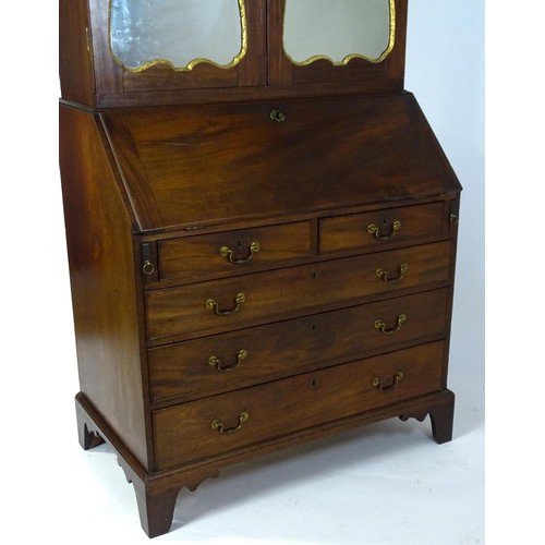 1431 - A George II mahogany bureau bookcase with a moulded cornice above two mirrored doors opening to show... 