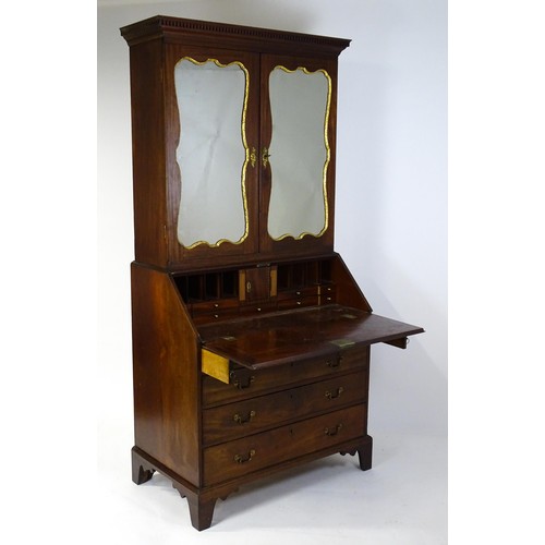 1431 - A George II mahogany bureau bookcase with a moulded cornice above two mirrored doors opening to show... 