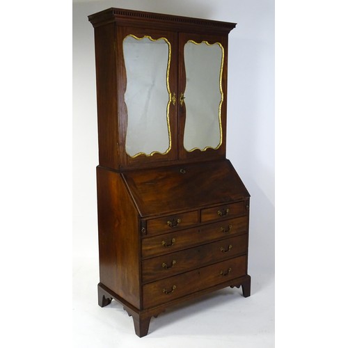 1431 - A George II mahogany bureau bookcase with a moulded cornice above two mirrored doors opening to show... 
