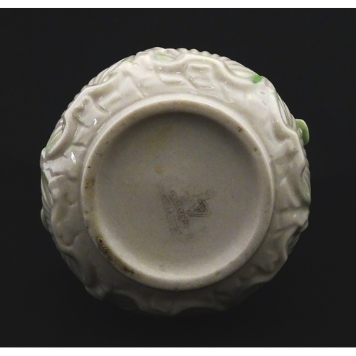 87 - A Belleek dolphin spill vase with twin fish handles and shell detail to base. Marked with Second Per... 