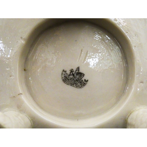 94 - A Belleek honey pot on stand of skep / beehive form decorated with bees, flowers and shamrocks. Rais... 