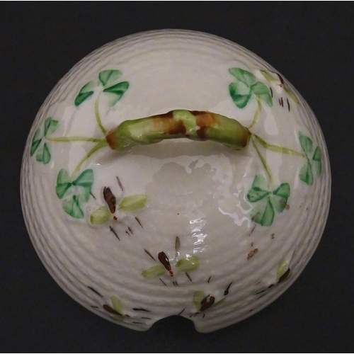 94 - A Belleek honey pot on stand of skep / beehive form decorated with bees, flowers and shamrocks. Rais... 
