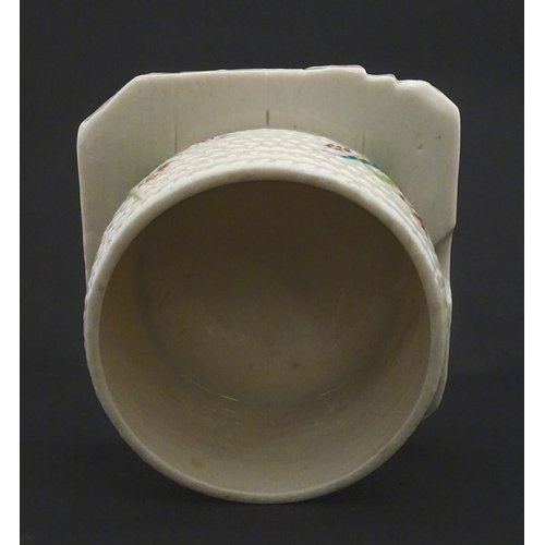 94 - A Belleek honey pot on stand of skep / beehive form decorated with bees, flowers and shamrocks. Rais... 