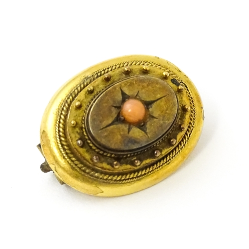 624 - A Victorian yellow metal brooch set with a coral cabochon to centre. Approx. 3/4