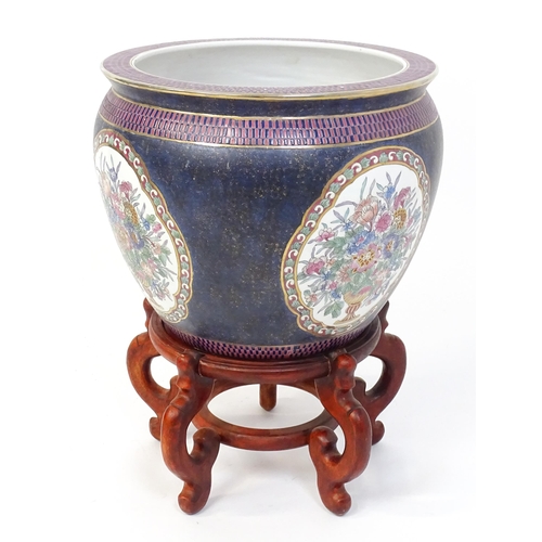 30 - A Chinese jardiniere decorated with panels depicting flowers and foliage, the interior decorated wit... 