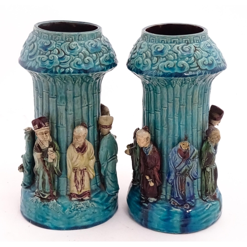 61 - A pair of Chinese vases with bamboo detail and decorated with the 7 immortals in relief. Approx. 10 ... 