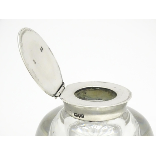 496 - A glass inkwell with silver lid hallmarked London 1901, maker Holland, Aldwinckle & Slater. Approx. ... 