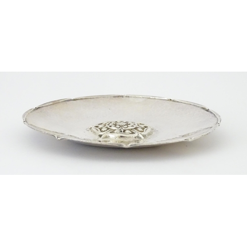 501 - An Arts & Crafts silver dish of circular form with hammered decoration and centre Tudor rose motif, ... 