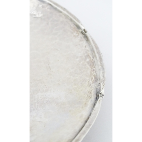 501 - An Arts & Crafts silver dish of circular form with hammered decoration and centre Tudor rose motif, ... 