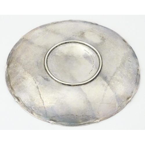 501 - An Arts & Crafts silver dish of circular form with hammered decoration and centre Tudor rose motif, ... 