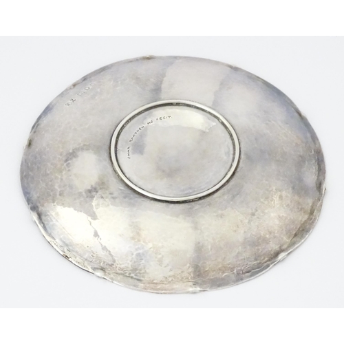 501 - An Arts & Crafts silver dish of circular form with hammered decoration and centre Tudor rose motif, ... 