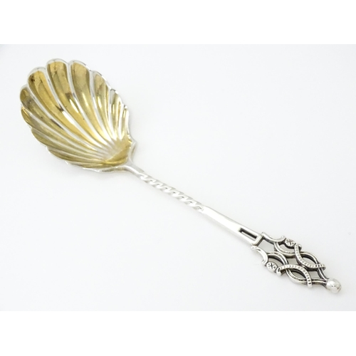 513 - A Victorian silver sugar spoon with shell formed bowl and openwork detail, hallmarked London 1894, m... 