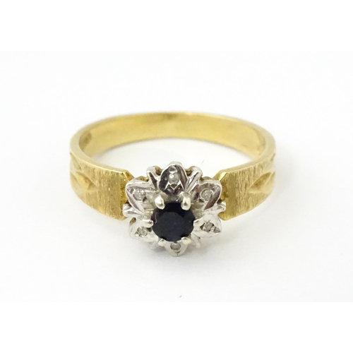 624 - A 9ct gold ring set with central sapphire bordered by diamonds. Ring size approx. L 1/2