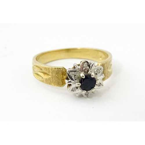 624 - A 9ct gold ring set with central sapphire bordered by diamonds. Ring size approx. L 1/2