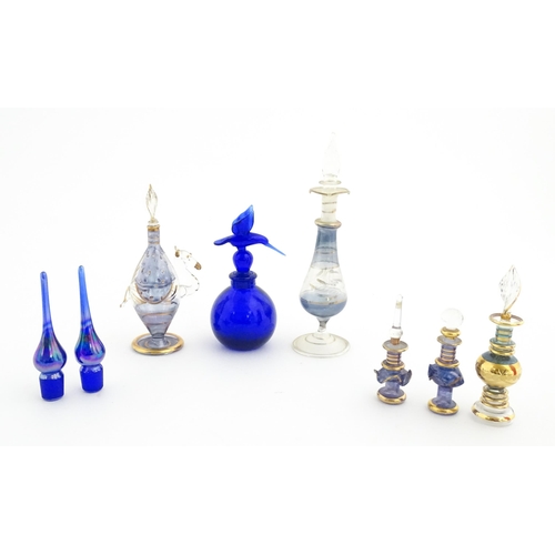 234 - Assorted glass scent / perfume bottles and various stoppers to include an Egyptian example formed as... 