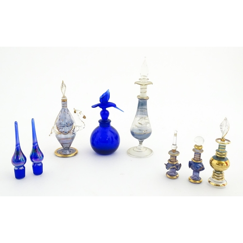 234 - Assorted glass scent / perfume bottles and various stoppers to include an Egyptian example formed as... 