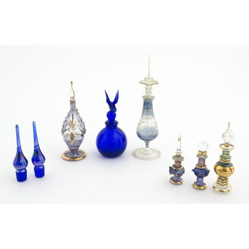 234 - Assorted glass scent / perfume bottles and various stoppers to include an Egyptian example formed as... 