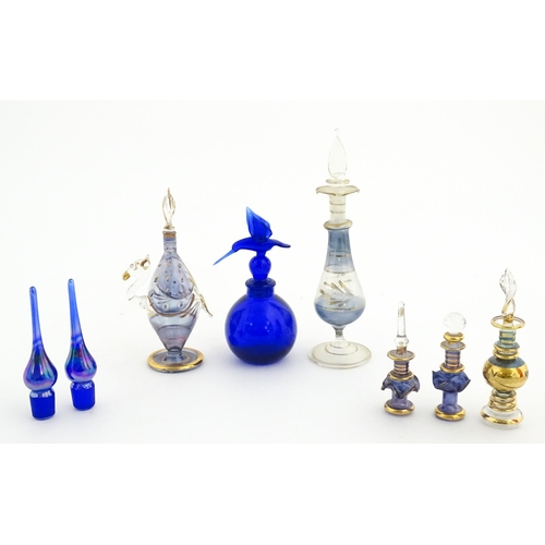 234 - Assorted glass scent / perfume bottles and various stoppers to include an Egyptian example formed as... 