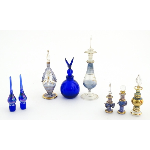 234 - Assorted glass scent / perfume bottles and various stoppers to include an Egyptian example formed as... 