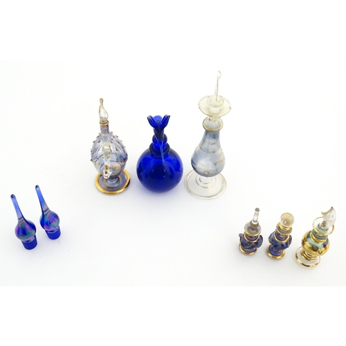 234 - Assorted glass scent / perfume bottles and various stoppers to include an Egyptian example formed as... 