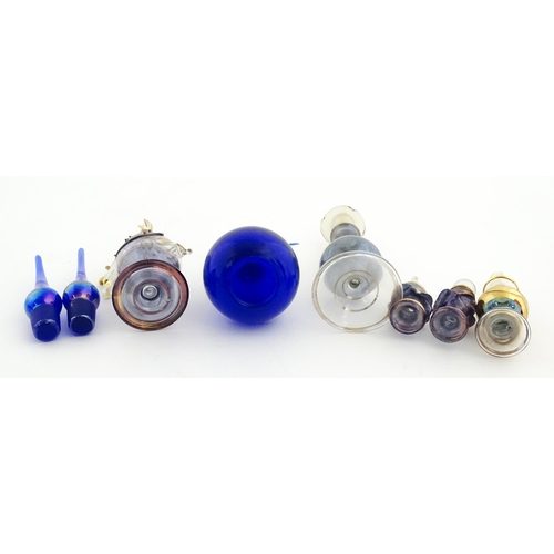 234 - Assorted glass scent / perfume bottles and various stoppers to include an Egyptian example formed as... 