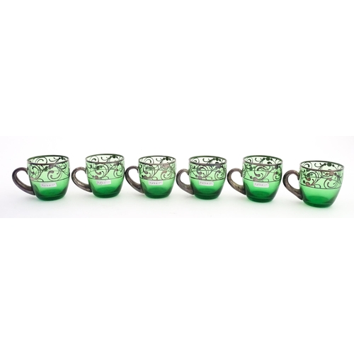 315 - A Spanish green glass punch bowl with ladle and six punch cups with silvered overlay detail. Marked ... 
