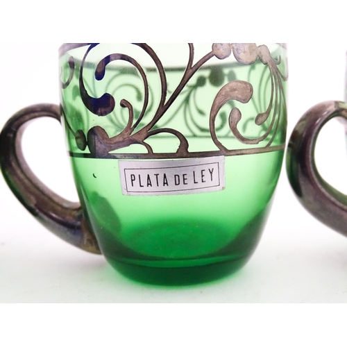 315 - A Spanish green glass punch bowl with ladle and six punch cups with silvered overlay detail. Marked ... 