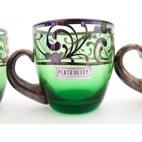 315 - A Spanish green glass punch bowl with ladle and six punch cups with silvered overlay detail. Marked ... 