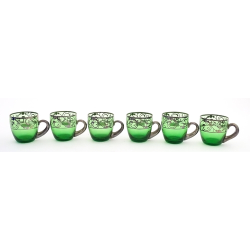 315 - A Spanish green glass punch bowl with ladle and six punch cups with silvered overlay detail. Marked ... 