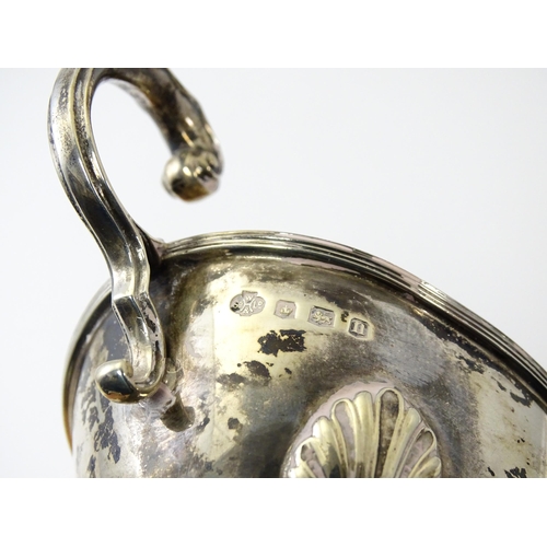 325 - A silver sauce boat raised on three feet with a scroll handle, hallmarked Sheffield 1930, maker Will... 
