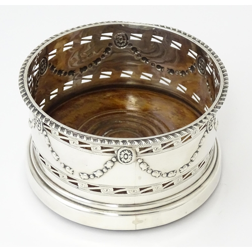 333 - A silver wine coaster with turned wooden base and swag detail, hallmarked Chester 1905, maker George... 