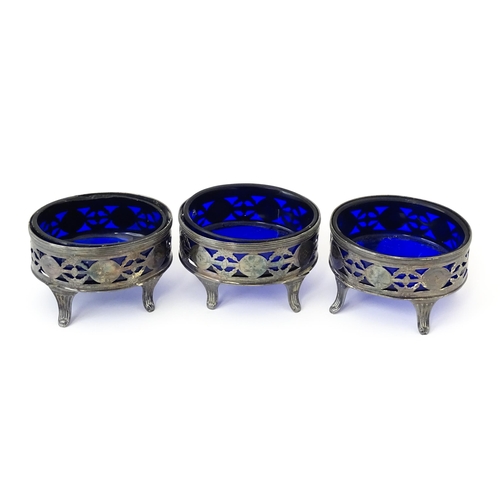 339 - A set of three George III silver salts of oval form with pierced decoration and blue glass liners, h... 