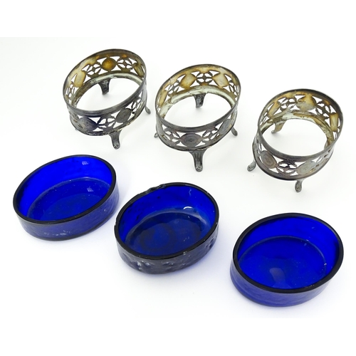 339 - A set of three George III silver salts of oval form with pierced decoration and blue glass liners, h... 