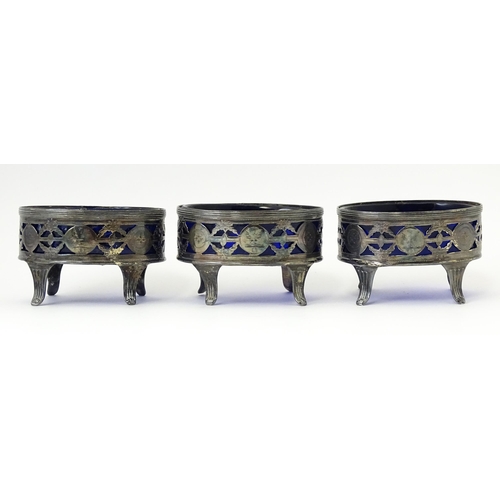 339 - A set of three George III silver salts of oval form with pierced decoration and blue glass liners, h... 