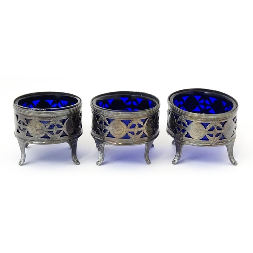 339 - A set of three George III silver salts of oval form with pierced decoration and blue glass liners, h... 