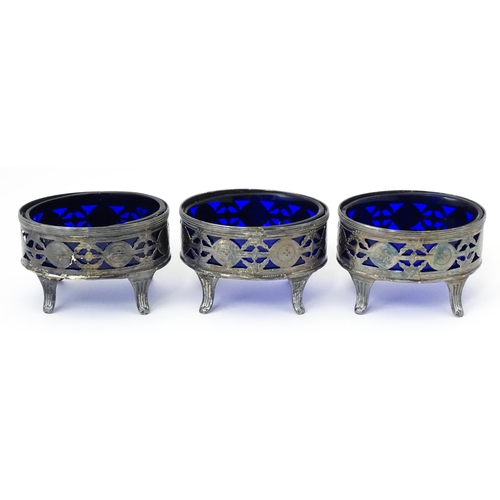 339 - A set of three George III silver salts of oval form with pierced decoration and blue glass liners, h... 